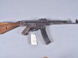 an akm machine gun with a wooden barrel and a wooden handle