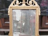 un miroir posé par terre devant une armoire