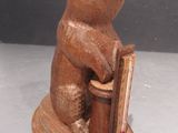 statue of a bear holding a book on top of a table
