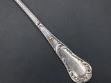 a silver spoon with a handle on a black surface
