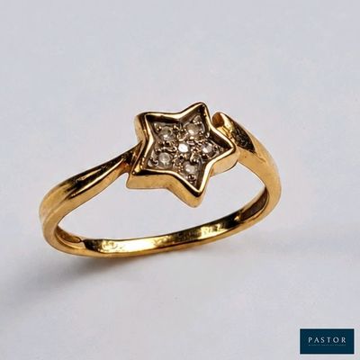 un gros plan d'une bague en or ornée d'une étoile en diamant