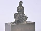 a statue of a woman sitting on top of a box