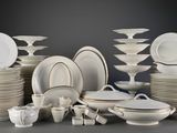 beaucoup d'assiettes et de bols blancs sur la table