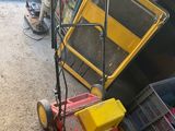 a lawn mower that is sitting on the ground next to a pile of trash