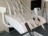 a picture of a medical room with a chair and a monitor