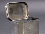 a small silver box with a lid on a table