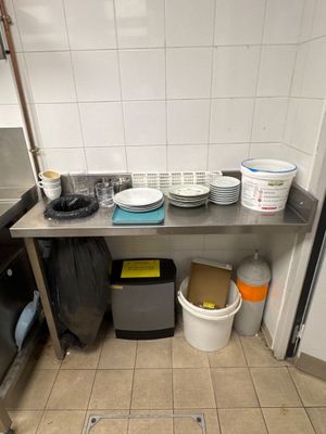 une cuisine avec un évier, une cuisinière et beaucoup de vaisselle sur le plan de travail