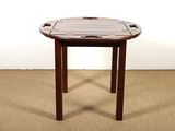 une petite table avec un plateau en bois sur un sol recouvert de moquette