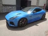 La voiture de sport bleue est garée devant un immeuble.