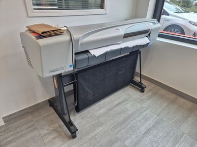 a printer sitting on a stand in front of a window