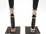 pair of black and gold candlesticks on wooden bases