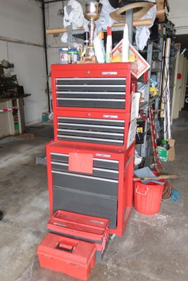 a garage with a red tool cabinet and a black and red tool box