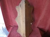 a wooden clock that is on display on a red cloth