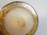 un gros plan d'un vase en verre recouvert d'une substance brune
