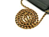 a black purse with a gold chain attached to it