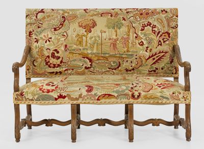 un canapé avec un dossier recouvert d'un tissu à motifs floraux et une structure en bois
