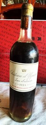 une bouteille de vin posée sur une table, à côté d'une boîte rouge