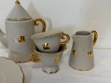 three cups and a teapot sitting on a table