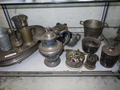 a glass shelf with a lot of silver items on it