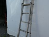a ladder leaning against a white wall next to a building