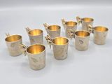 a set of six silver cups with gold rims