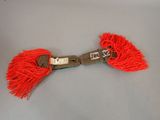 a red tassel with a metal buckle on it