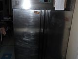 a stainless steel refrigerator in a room with a blue and white checkered floor