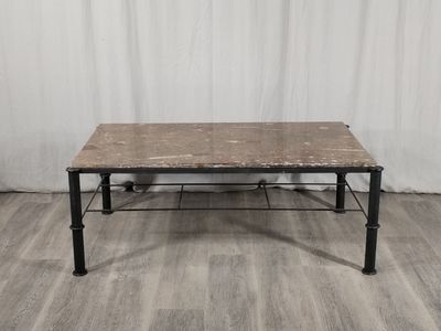 La table est en bois et en métal, avec un plateau en marbre.