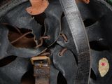 an old green helmet with a leather band and a metal buckle