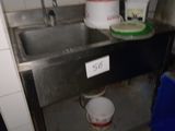 un évier sale dans une cuisine sale, avec de la vaisselle sale