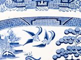 a blue and white plate with birds and flowers on it