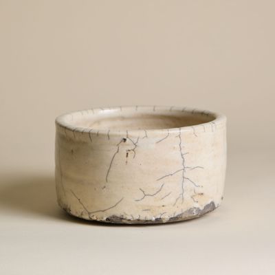 un bol blanc à la surface craquelée posé sur une table