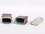 three small pieces of glass sitting on a white surface