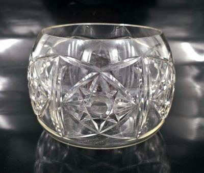 un saladier en verre transparent posé sur une table avec un fond noir