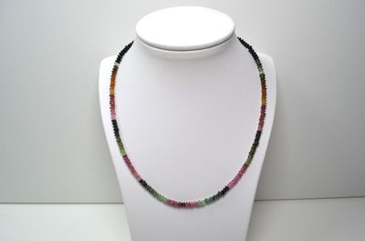 un gros plan d'un collier orné de perles multicolores porté par un mannequin