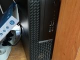 un ordinateur de bureau posé sur un bureau, à côté d'une manette Wii