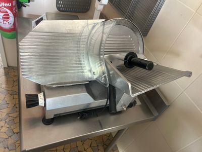 a meat slicer sitting on a table in a kitchen