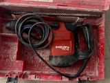 une boîte à outils rouge contenant une perceuse et un cordon d'alimentation