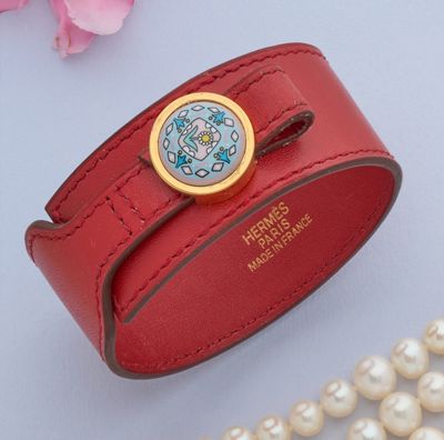 un bracelet en cuir rouge muni d'un fermoir en or et d'une perle