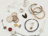 de nombreux colliers et bracelets de toutes sortes disposés sur une surface blanche