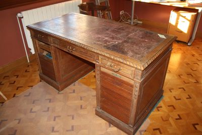 a wooden desk with a marble top in the middle of a room