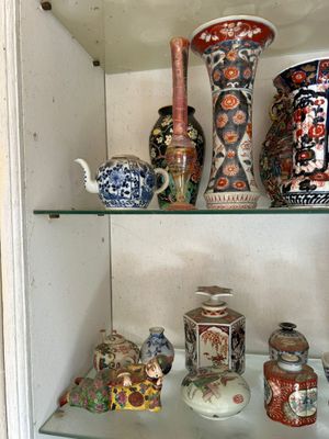 many different vases on the shelves in this cabinet