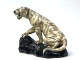 a figurine of a tiger sitting on a rock