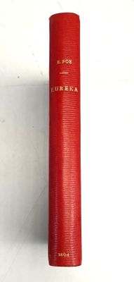 un vieux livre rouge posé sur une table blanche