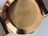 an image of a close up of a gold watch with a black strap