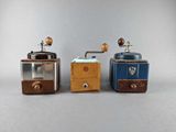 three different types of coffee grinders on a gray surface