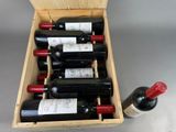 bottles of wine are in a wooden box on a table