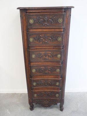 une vieille commode en bois avec des sculptures ornementales sur les tiroirs