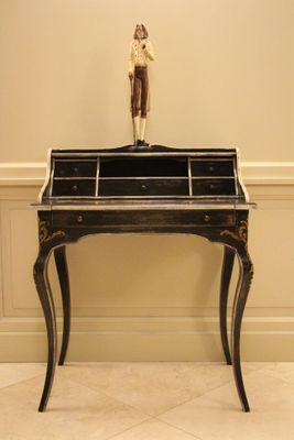 un petit bureau sur lequel se trouve la statue d'un homme