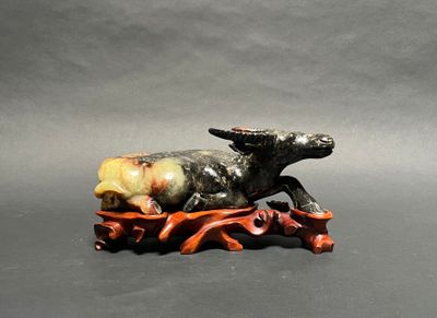 a small figurine of a bull on a wooden stand